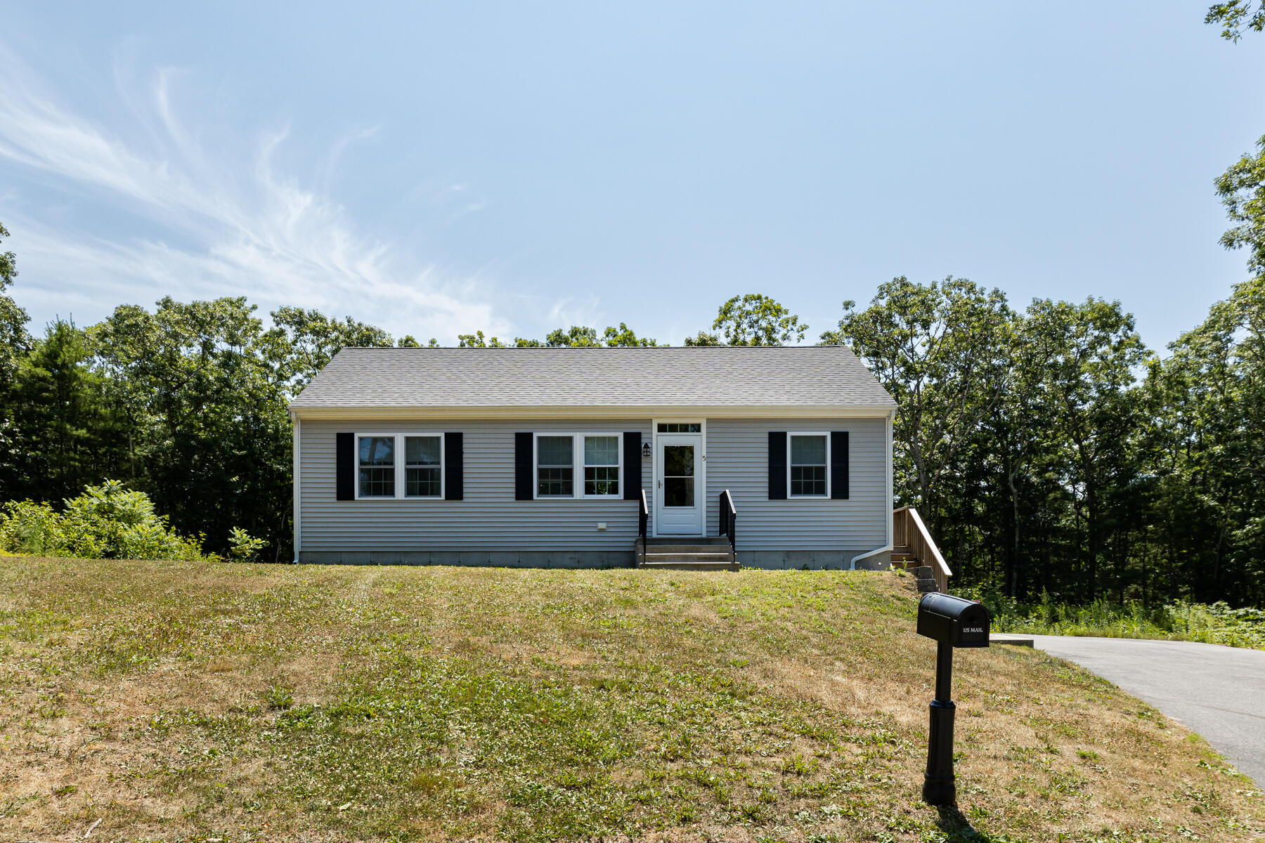 a front view of house with yard space and trees around