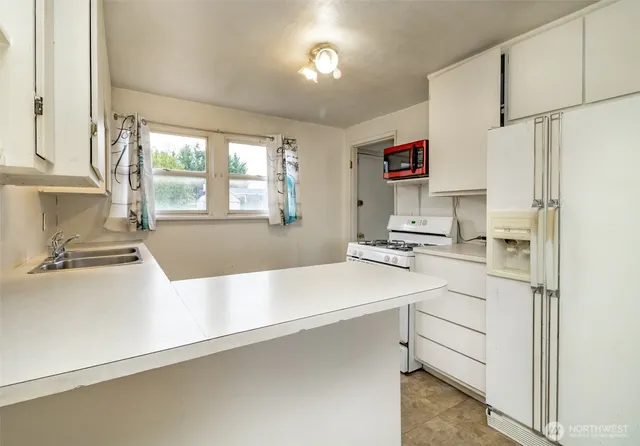 a kitchen with a sink appliances and a window