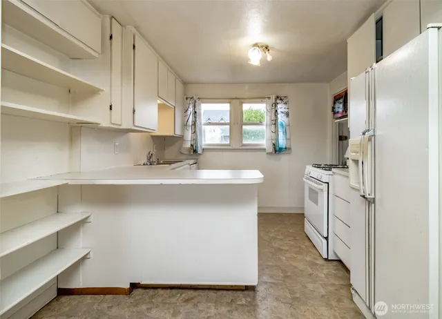 a kitchen with white cabinets and white appliances