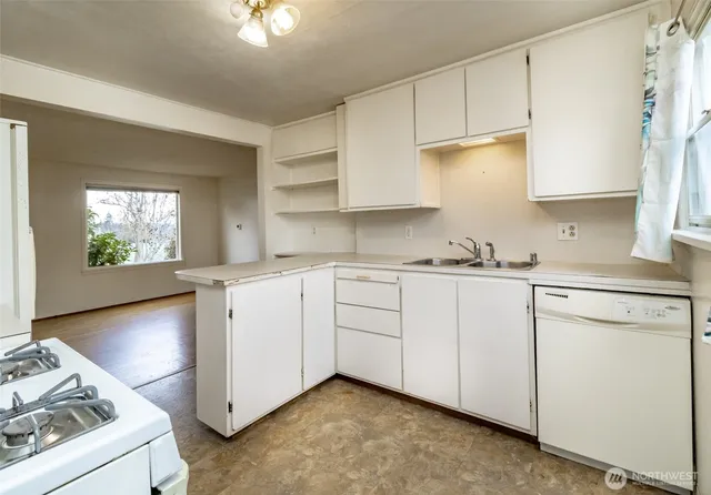 a kitchen with granite countertop white cabinets and white appliances