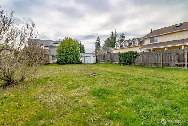 a view of a yard with an house and wooden fence