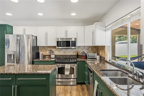 a kitchen with kitchen island granite countertop a sink stove and refrigerator