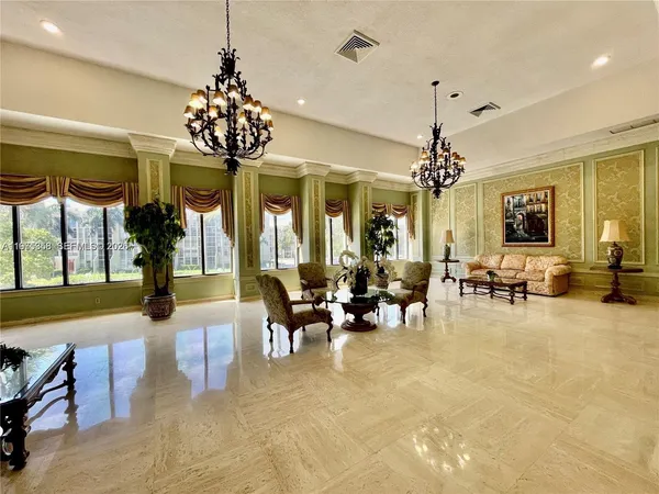 a view of a dining room with furniture a chandelier and large windows