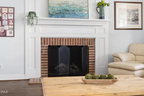 a living room with furniture a rug wooden floor and a large window