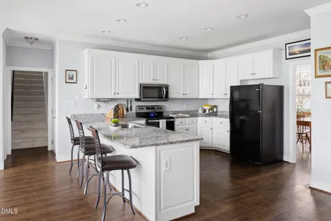 a kitchen with stainless steel appliances granite countertop a refrigerator stove microwave and sink