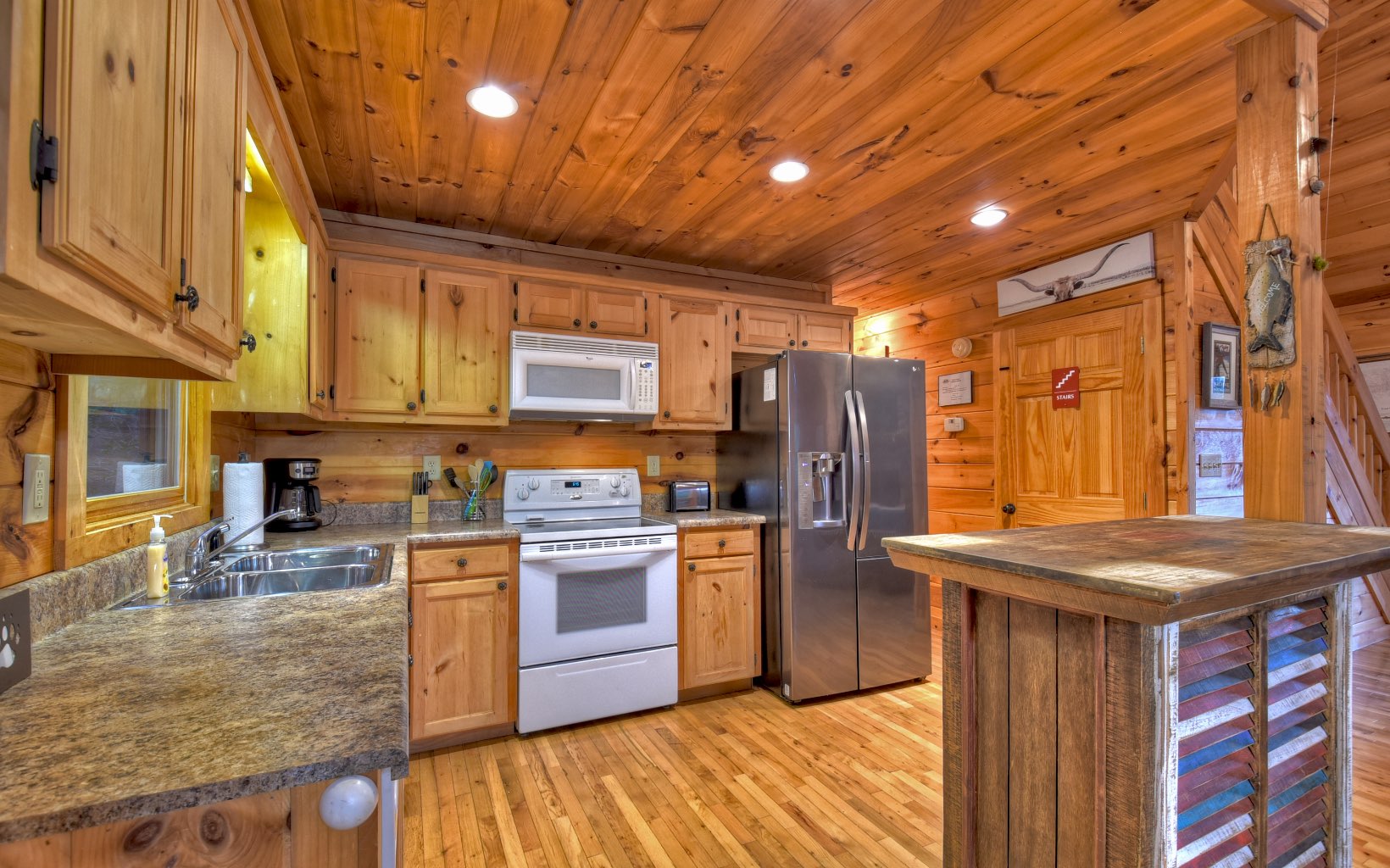 216 The Forest Road Blue Ridge, GA 30513 - Photo 26 of 41 a kitchen with stainless steel appliances granite countertop a sink a stove a refrigerator cabinets and wooden floor