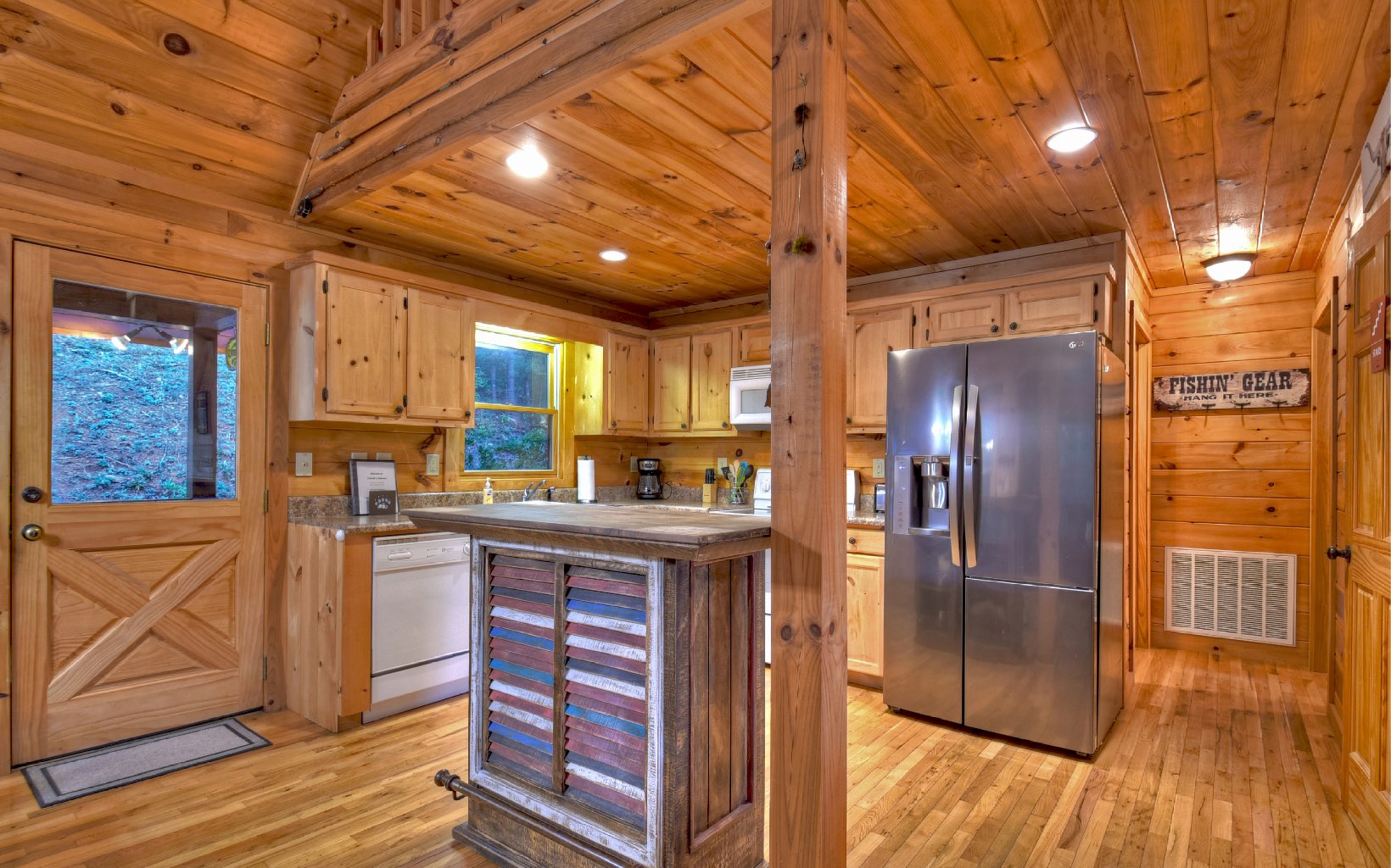 216 The Forest Road Blue Ridge, GA 30513 - Photo 6 of 41 a kitchen with stainless steel appliances granite countertop a refrigerator a sink dishwasher a stove and white countertops with wooden floor