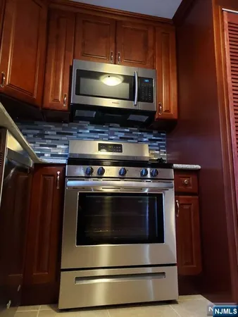 a stove top oven sitting inside of a kitchen and granite counter tops