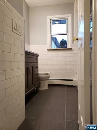 a bathroom with a toilet a sink and mirror