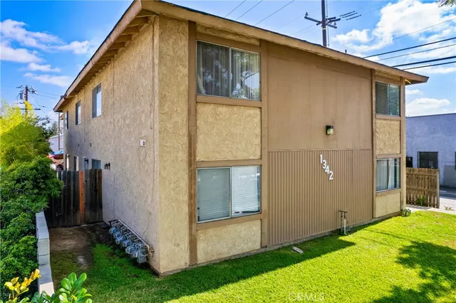 a backyard of a house with plants and wooden fence