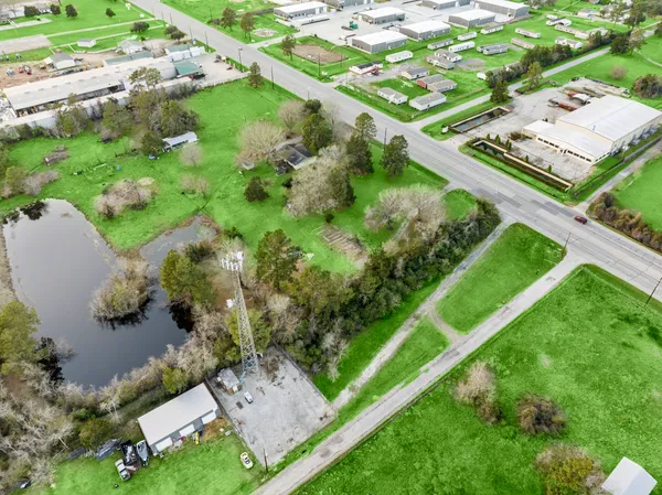 an aerial view of residential houses with outdoor space and trees
