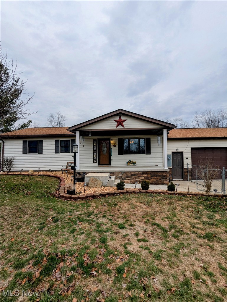 Ranch-style house with covered porch and a front yard