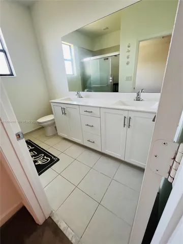 a bathroom with a double vanity sink and a mirror