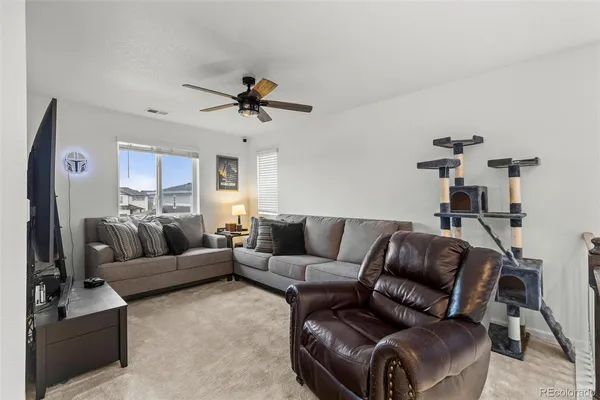 a living room with furniture and a wooden floor