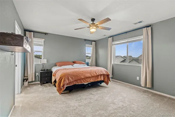 a spacious bedroom with a bed and a chandelier