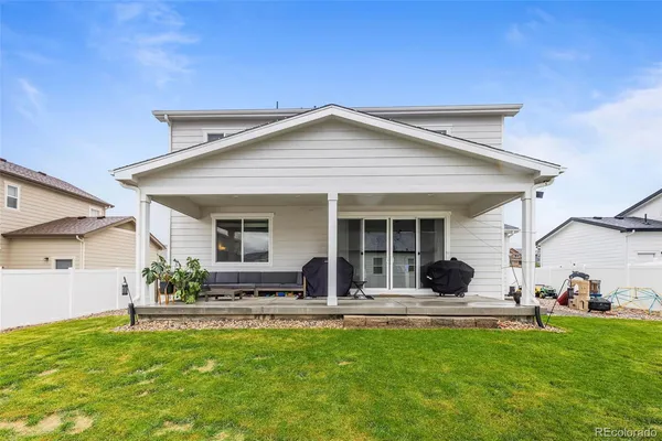 a view of a house with a backyard porch and furniture
