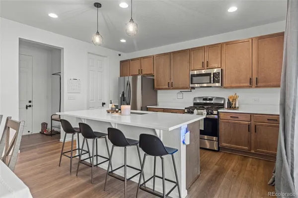 a kitchen with stainless steel appliances a stove a sink a microwave a refrigerator and cabinets