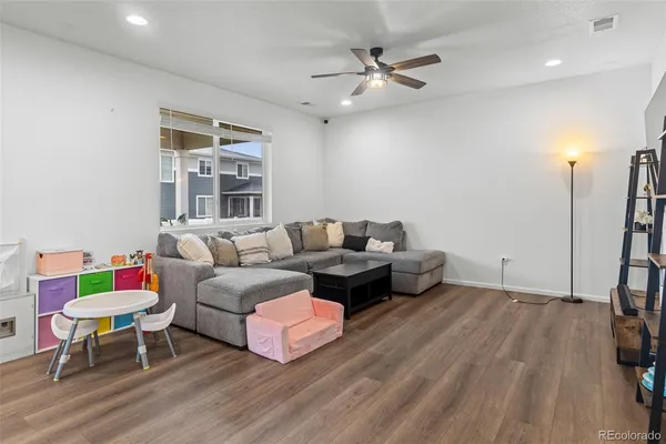 a living room with furniture and a wooden floor