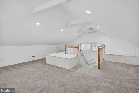 an empty room with a white wall and ceiling fan