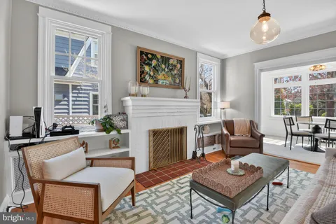a living room with furniture a fireplace and next to a window