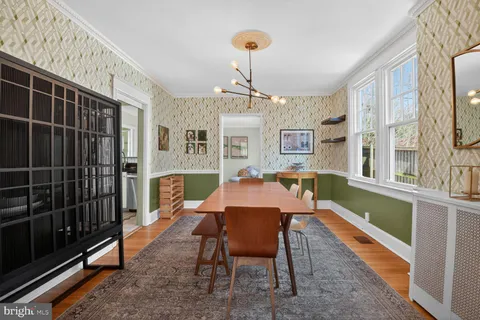 a dining room with furniture a chandelier and wooden floor