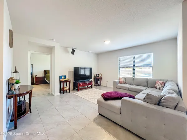 a living room with furniture and kitchen view