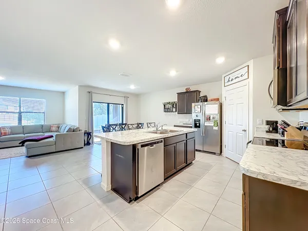a kitchen with granite countertop a sink dishwasher stove and cabinets