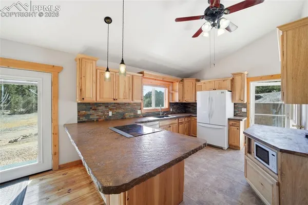 a kitchen with stainless steel appliances granite countertop a sink a stove and a refrigerator