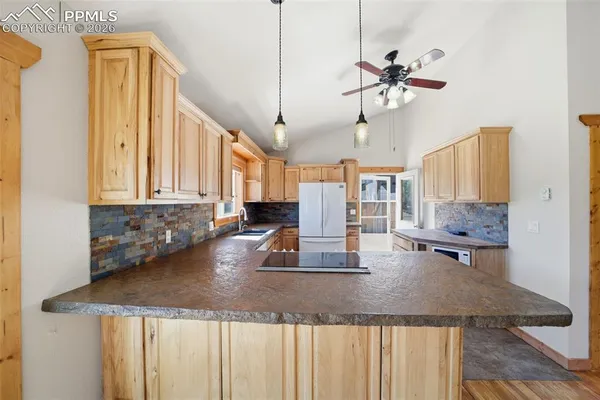 a kitchen with a sink a counter top space and living room view
