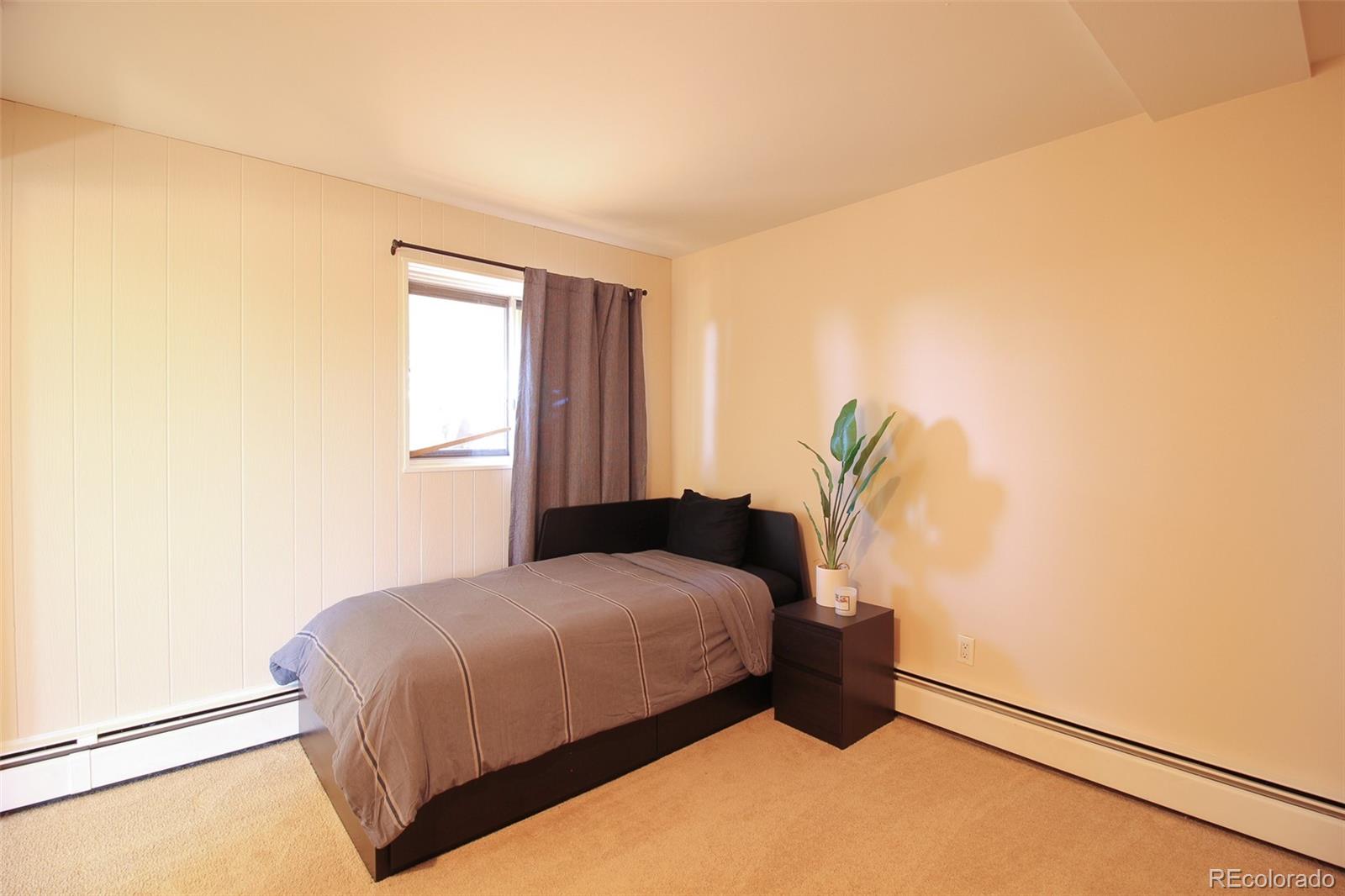 243 Paradise Road Golden, CO 80401 - Photo 32 of 49 a bedroom with a bed and a potted plant