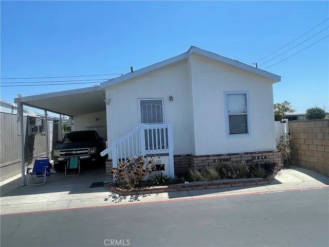 a front view of a house with cars parked