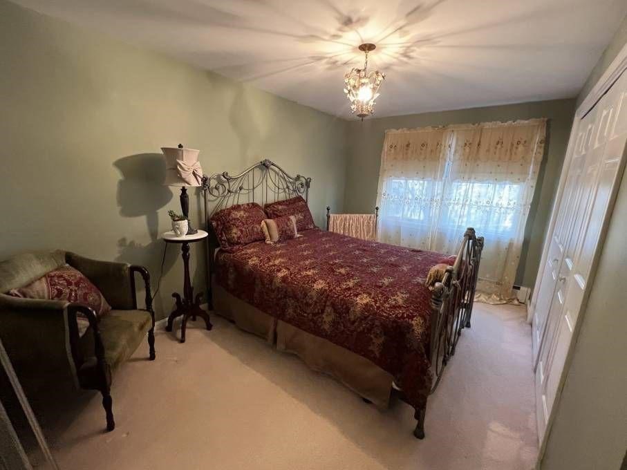 30 Katharine Lee Bates Road Falmouth, MA 02540 - Photo 11 of 15 a bedroom with a bed and a chandelier