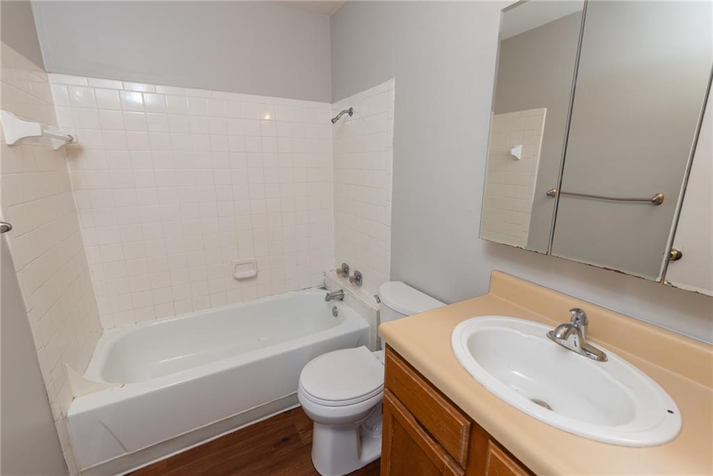 3115 Helms Street, Unit 116 Austin, TX 78705 - Photo 4 of 12 Bathroom with vanity, shower / bathtub combination, and dark wood finished floors