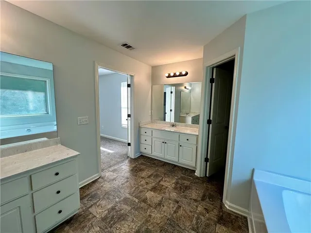a bathroom with a double vanity sink toilet mirror and bathtub