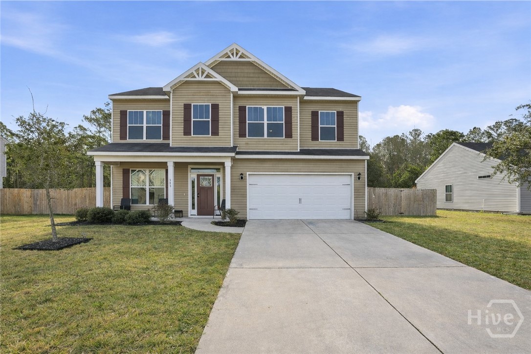 Two-story suburban home with beige siding, white trim, burgundy shutters, double garage, covered front porch, and large driveway in a residential neighborhood with fenced backyard.