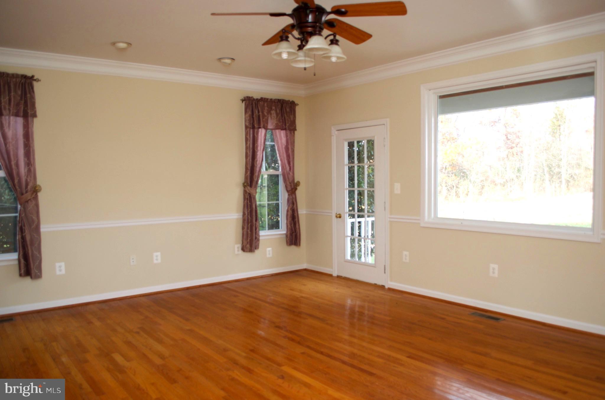 4113 Summit Point Road Charles Town, WV 25414 - Photo 14 of 27 a view of an empty room with wooden floor and a window