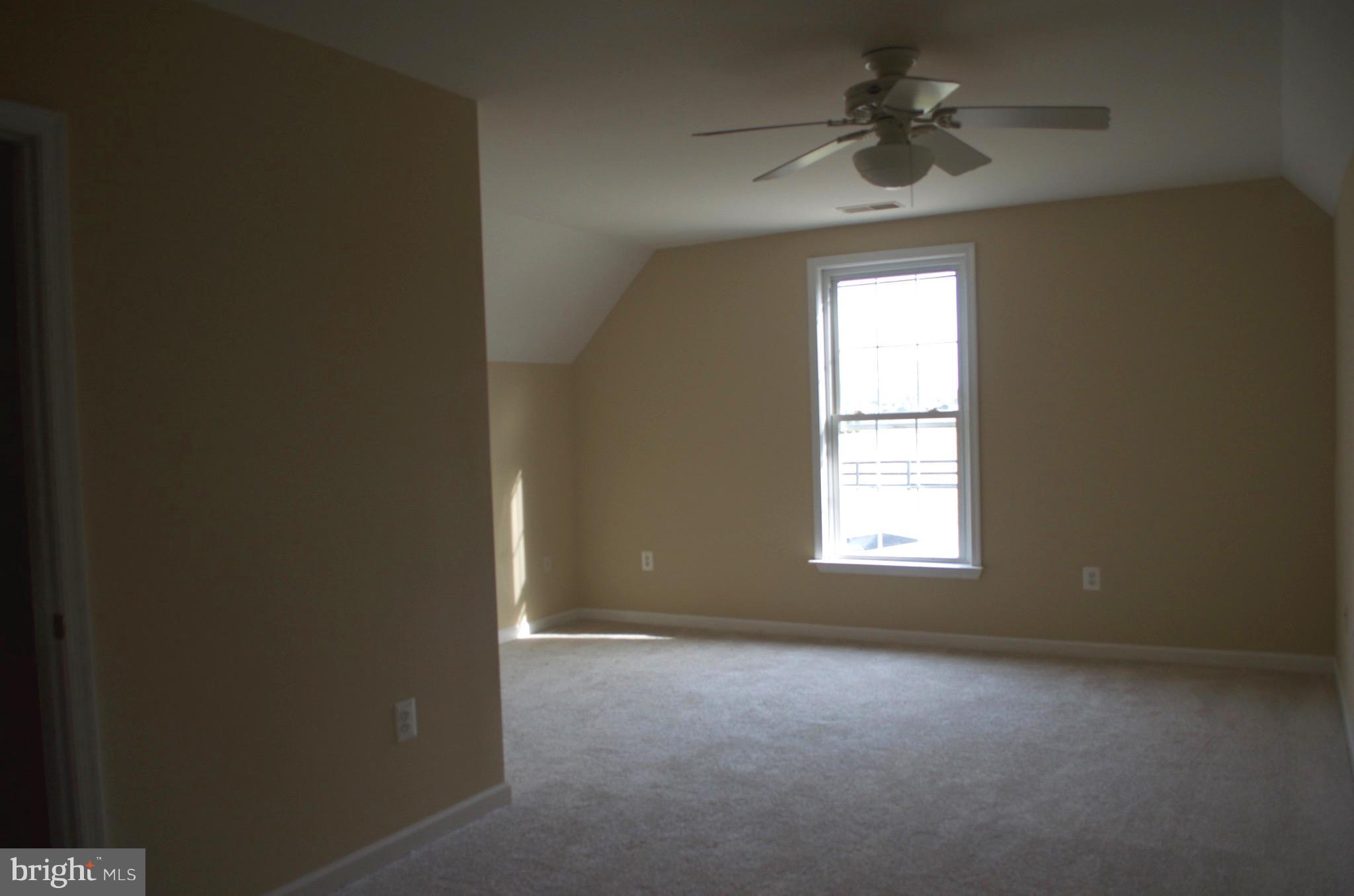 4113 Summit Point Road Charles Town, WV 25414 - Photo 22 of 27 an empty room with a window and a fan