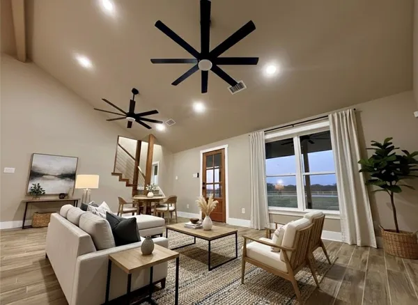 a view of an empty room with kitchen and a window