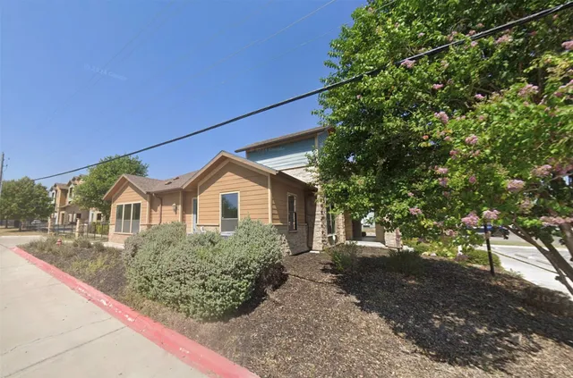 a front view of a house with a garden and yard