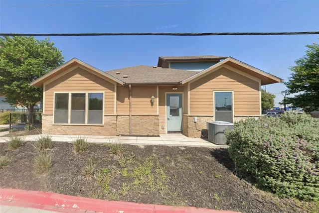 a front view of a house with a yard and potted plants