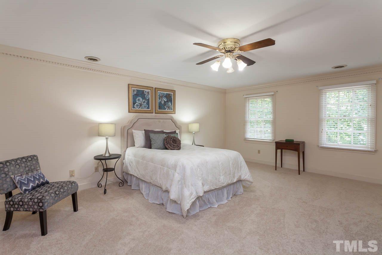 2901 Patrie Place Raleigh, NC 27613 - Photo 13 of 25 a spacious bedroom with a bed and a chandelier
