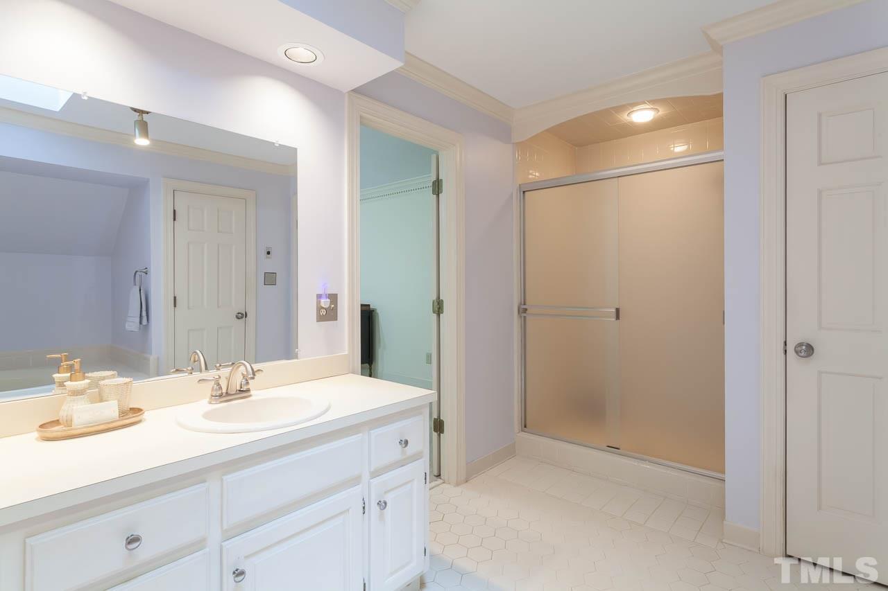 2901 Patrie Place Raleigh, NC 27613 - Photo 17 of 25 a bathroom with a shower sink vanity and mirror