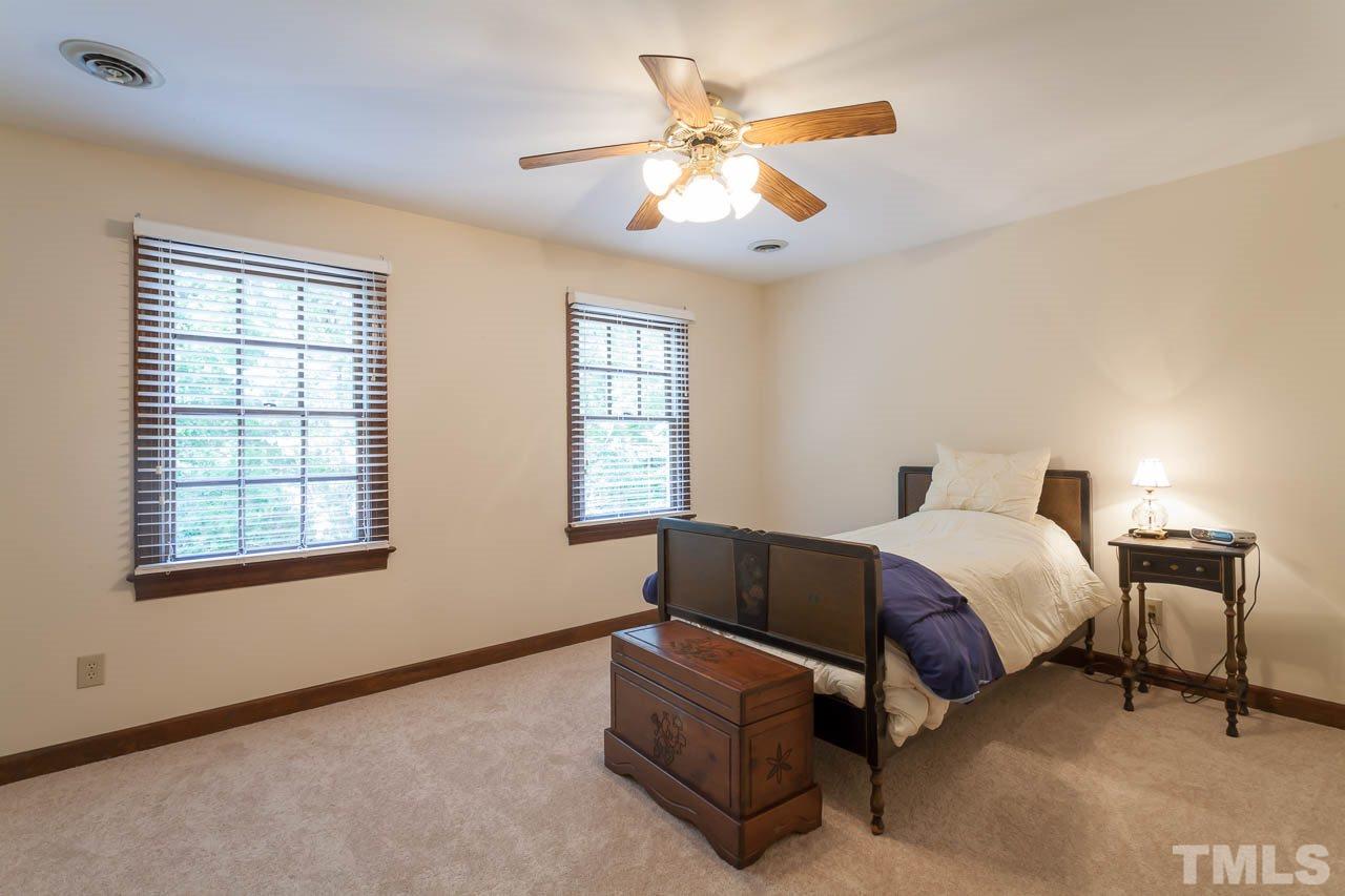 2901 Patrie Place Raleigh, NC 27613 - Photo 18 of 25 a spacious bedroom with a bed and a chandelier