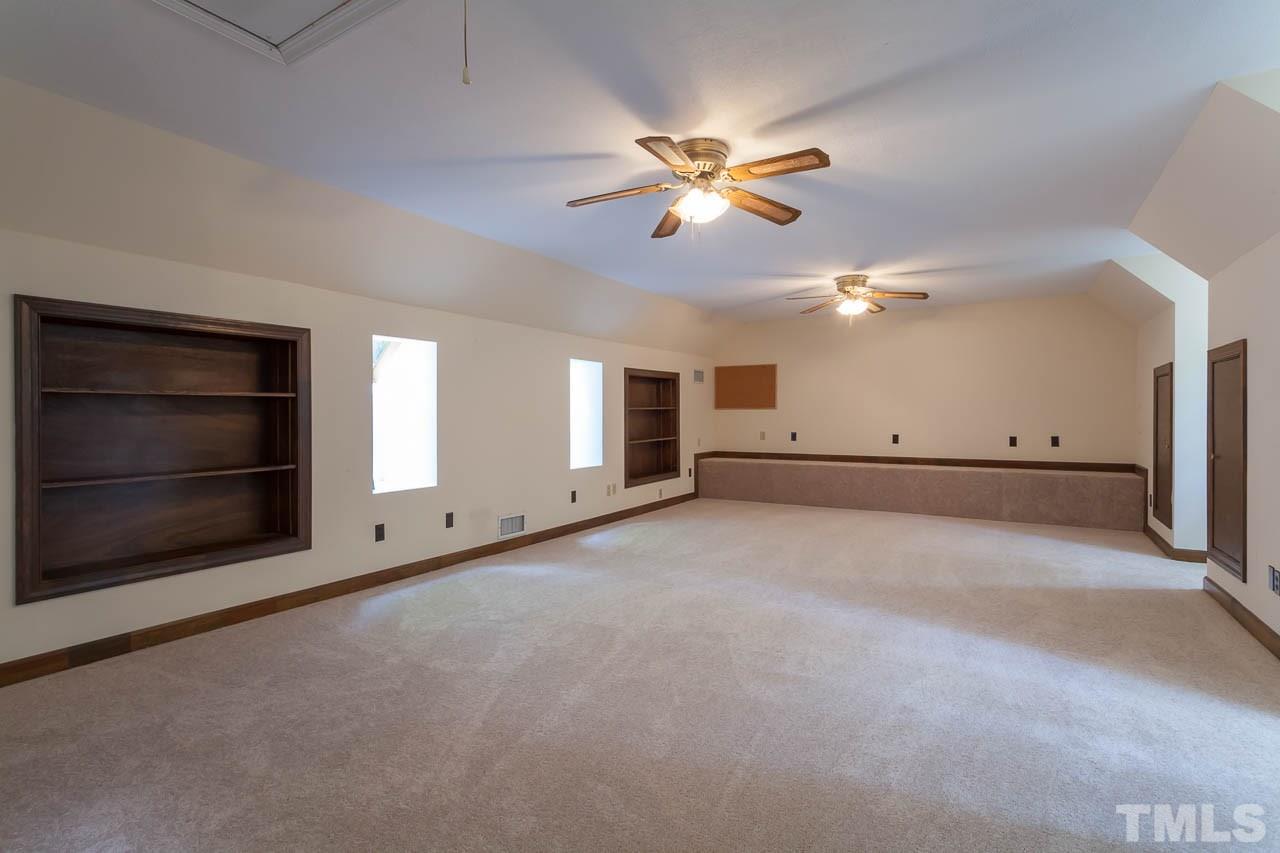 2901 Patrie Place Raleigh, NC 27613 - Photo 21 of 25 a view of an empty room with a fireplace and a fan