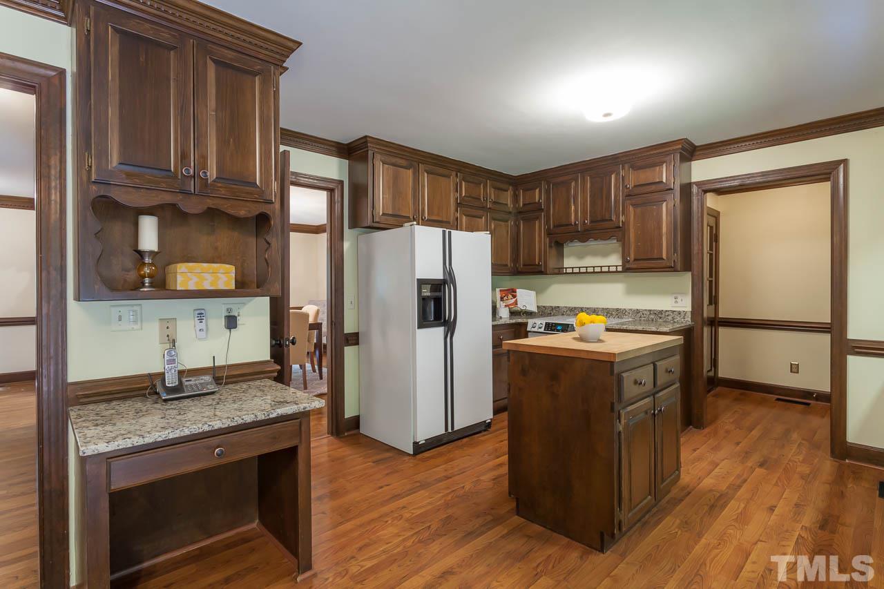 2901 Patrie Place Raleigh, NC 27613 - Photo 10 of 25 a kitchen with stainless steel appliances granite countertop a refrigerator a stove and a wooden floors