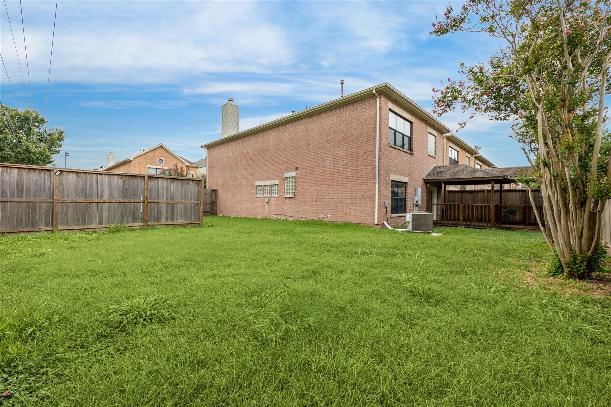 9829 Riddlelink Lane Houston, TX 77025 - Photo 20 of 22 Alternate view of the large yard and covered deck, offering both shade and open green space for outdoor enjoyment.