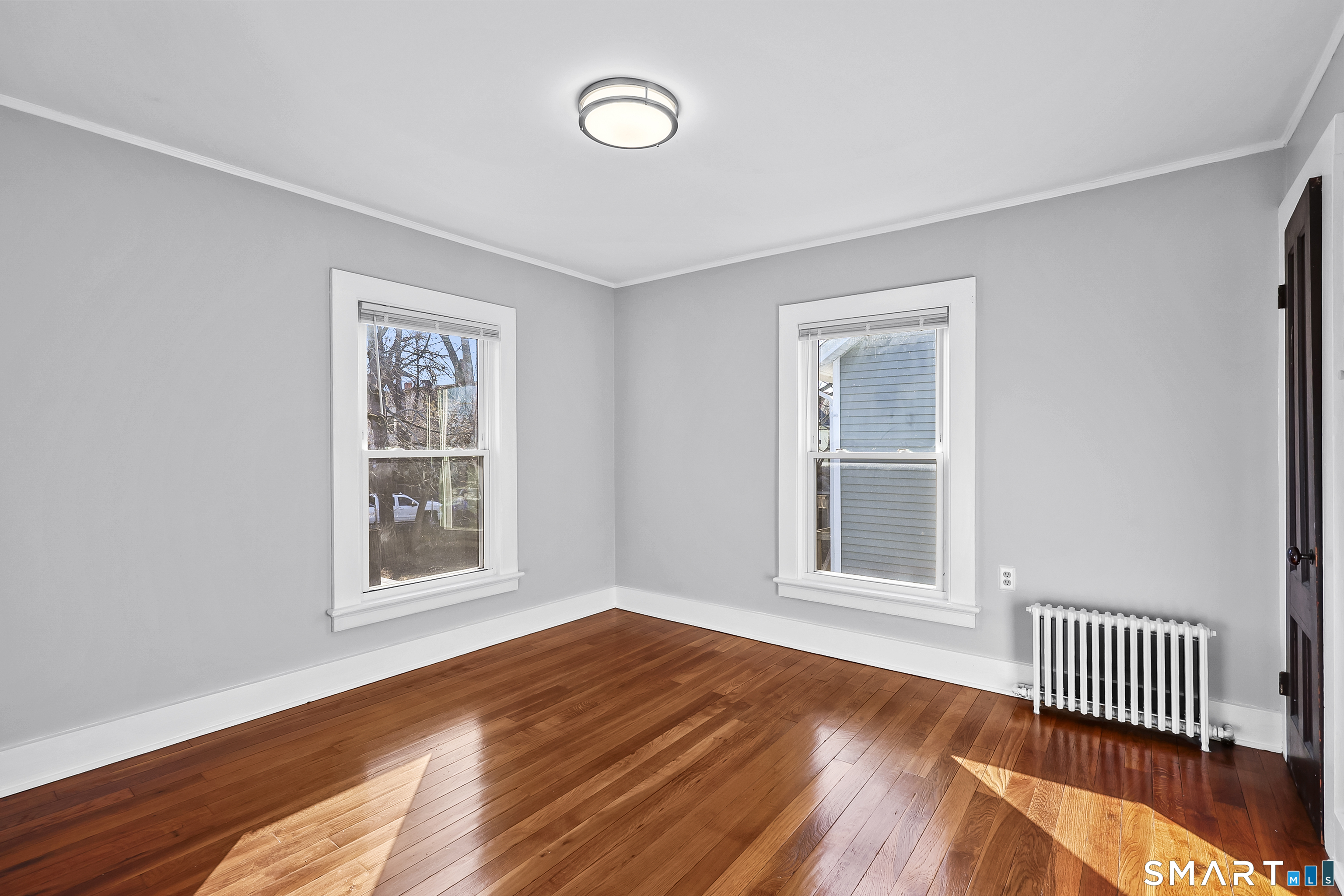 59 Grand Street Middletown, CT 06457 - Photo 16 of 33 an empty room with wooden floor and windows