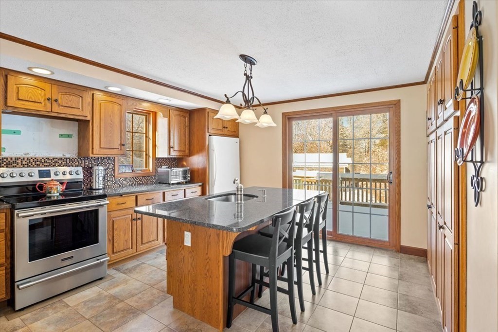 5 Sandy Lane Assonet, MA 02702 - Photo 14 of 34 a dining hall with stainless steel appliances granite countertop a stove top oven a sink dishwasher a dining table and chairs with wooden floor