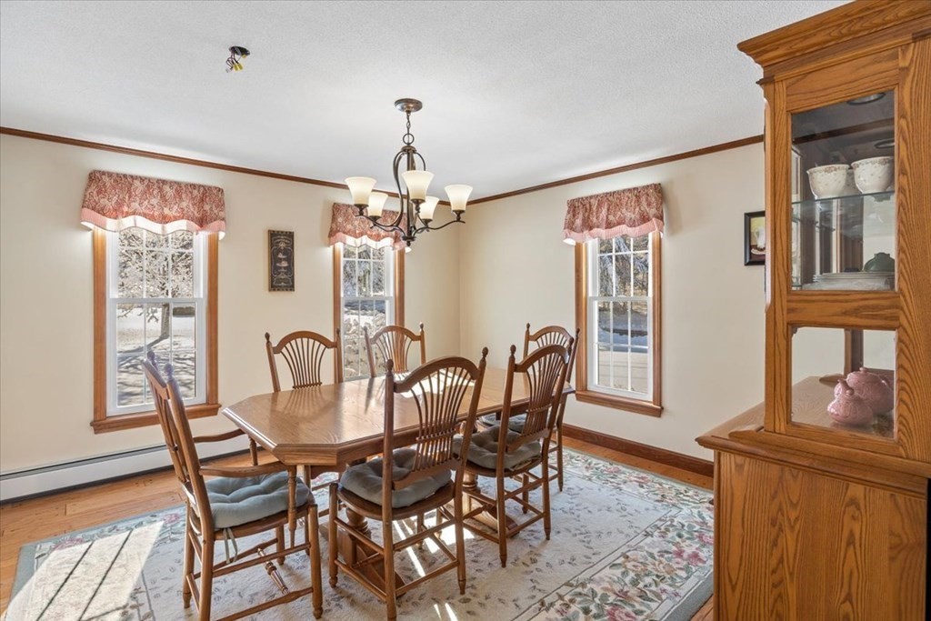 5 Sandy Lane Assonet, MA 02702 - Photo 17 of 34 a dining room with furniture a chandelier and wooden floor