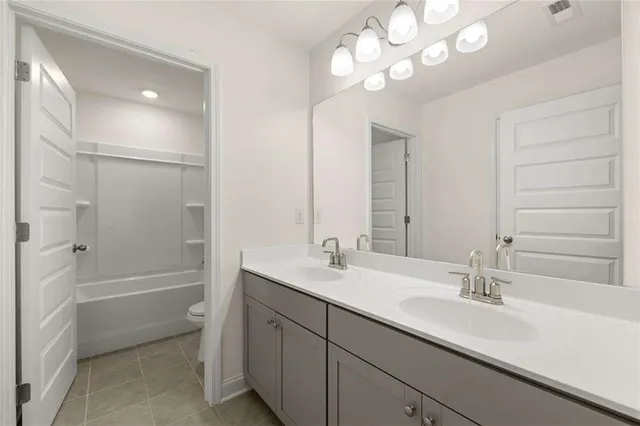 a bathroom with a sink a toilet a shower and a mirror